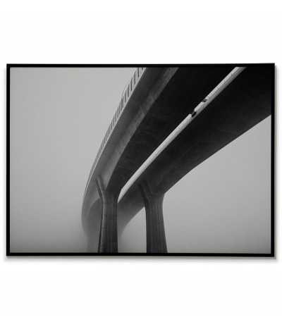 Prints on the wall in the form of a poster with a photograph of the bridge in the fog. Black and white picture